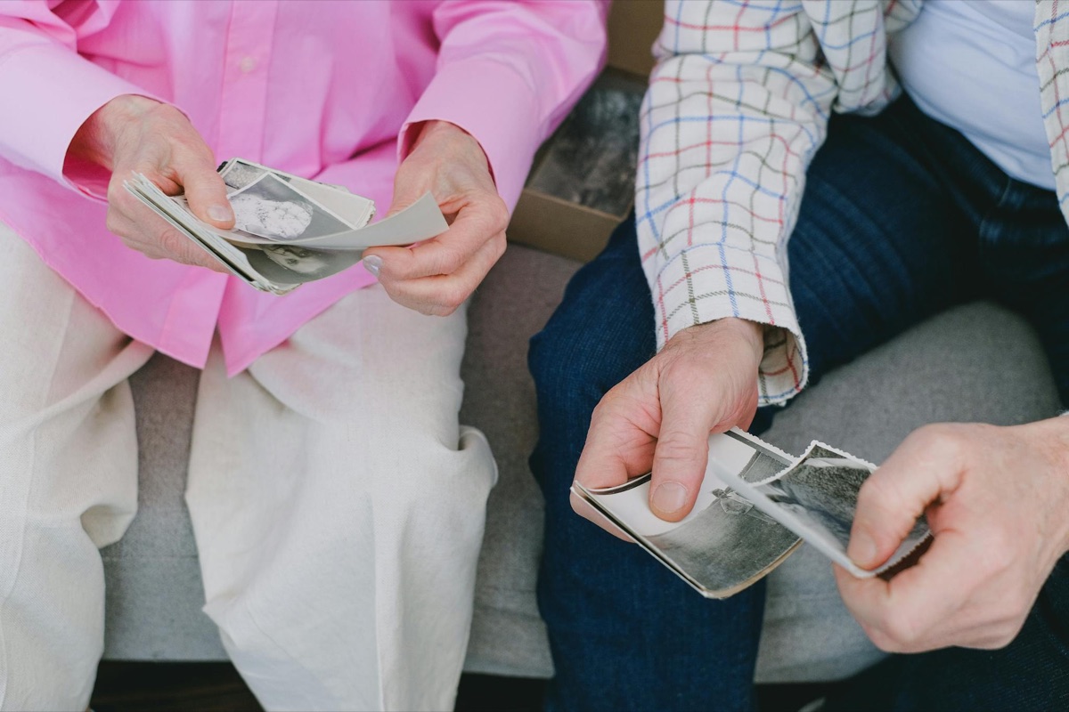 Two people sharing and looking through old family photographs together